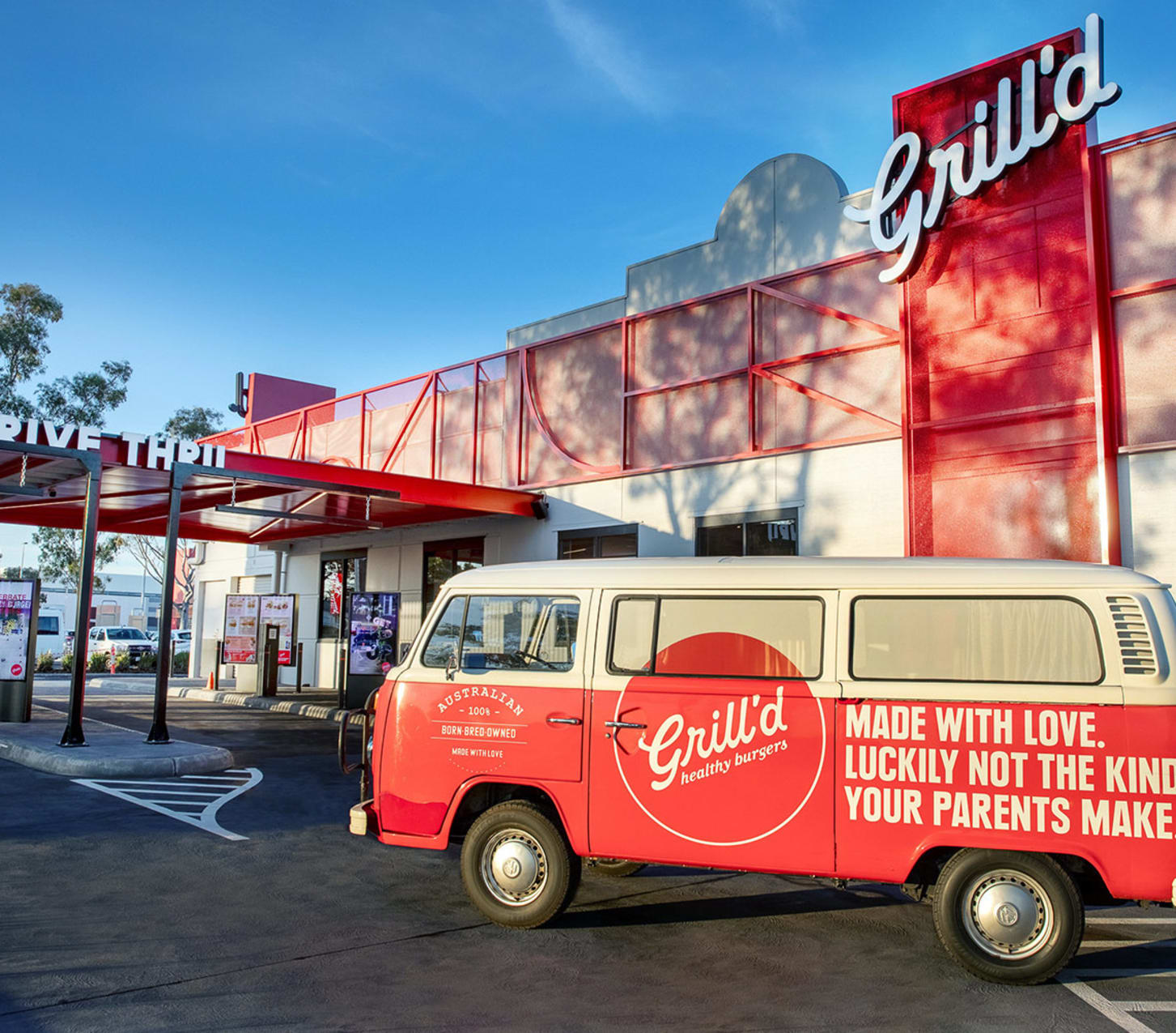 A Grill'd van parked outside the Grill'd restaurant, positioned near the drive-thru entrance.